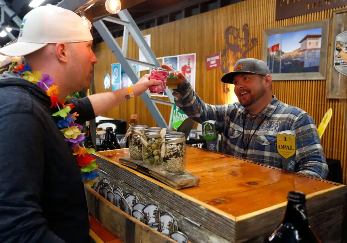 Gary Corsiglia, left, of Santa Rosa raises a glass to Jessie Ashdown of Firestone Walker Brewing Company during Battle of the Brews at Grace Pavilion in Santa Rosa, California on Saturday, April 9, 2016. (Alvin Jornada / The Press Democrat)